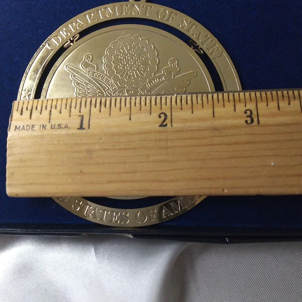 DEPARTMENT OF STATE GOLD TONE ORNAMENT IN BOX